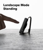 iPhone 16 Cover | Folio Grip Wallet Magnetic - iPhone 16 Cover - A hand touches a phone in a folio case folded into a stand on a textured surface against a bright background.