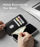 iPhone 18 Pro Max MagSafe Wallet | Folio Grip Wallet Magnetic - A black leather wallet phone case shown open with hands inserting cash and holding cards, placed over a smartphone on a gray surface. White text at the top reads 'Holds Everything You Need' and 'Store up to 4 cards, cash, receipts and more.