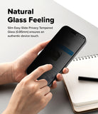 iPhone 18 Pro / Pro Max Privacy Screen & Camera Protectors all-groups - A person holds a smartphone with a dark privacy screen protector in both hands over a light gray desk, with a notebook and pen nearby. Text on the left reads 'Natural Glass Feeling' and describes slim easy slide privacy tempered glass.