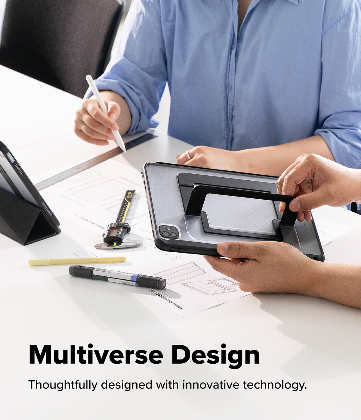 Ringke Apple iPad Pro (11") / Air (11", 10.9") Case [Multiverse Case] - A person holds a black tablet in a stand mode on a white desk, with another person in a light blue shirt writing on paper nearby. The image includes the text 'Multiverse Design' and 'Thoughtfully designed with innovative technology.