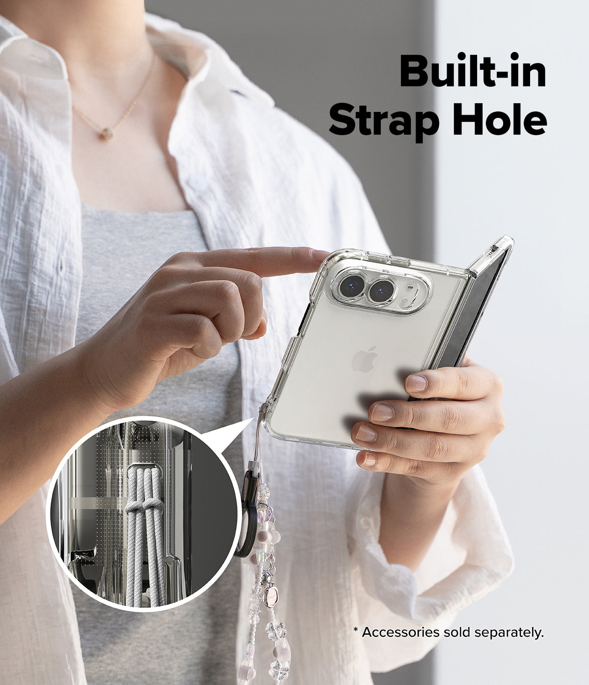 iPhone Duo | Fusion - A person holds a clear foldable phone case with a built-in strap hole and dangling charm, shown against a light gray background with the text 'Built-in Strap Hole' and a circular inset detail of the strap hardware.