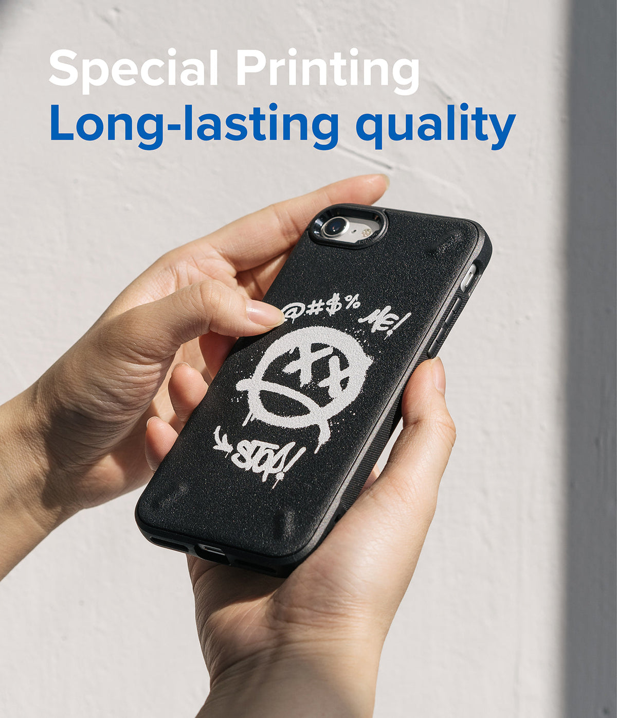 iPhone SE 2022 5G / SE 2020 / 8 / 7 Case | Onyx Design - Hands holding a black phone case with a white graffiti-style smiley face.