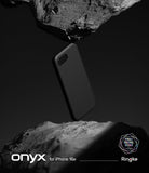 iPhone 16e Case | Onyx - A black phone case suspended between two jagged, dark rocks against a minimalist background.