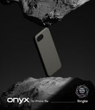 iPhone 16e Case | Onyx - A matte black phone case suspended between two jagged, dark grey rocks against a black background.
