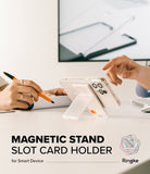 Card Holder | Magnetic Stand Slot - Clear magnetic phone stand and card holder propped up on a desk during a meeting.