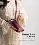 Mini Cross Bag | PU Leather - Person wearing a floral dress holding a burgundy PU leather phone bag with a strap closure.