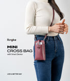 Mini Cross Bag | PU Leather - A person wearing a burgundy PU leather mini crossbody bag containing a smartphone.
