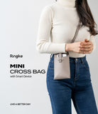 Mini Cross Bag | PU Leather - Woman wearing a beige PU leather mini crossbody bag holding a smartphone against a white background.