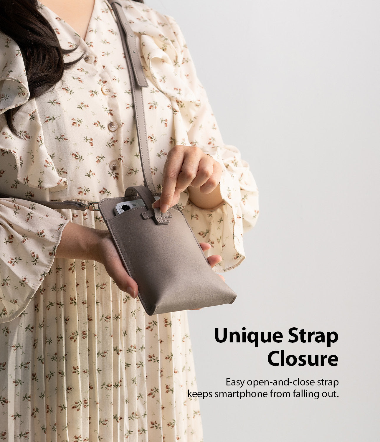 Mini Cross Bag | PU Leather - A person in a floral dress secures a smartphone inside a grey PU leather mini crossbody bag.