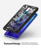 Redmi K30 Case | Fusion-X - Black protective phone case with 3D camouflage pattern hovering above a blue smartphone.