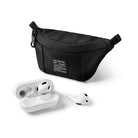 Mini Pouch | Sling Bag - Black textured mini sling bag with a branded patch next to white wireless earbuds and a charging case.