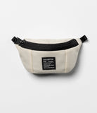 Mini Pouch | Sling Bag - Cream-colored mini sling bag with a black zipper and a rectangular brand patch on a white background.