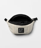 Mini Pouch | Sling Bag - Open cream-colored canvas pouch with black zipper and a rectangular brand label on the front.