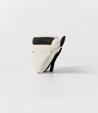 Mini Pouch | Sling Bag - Side profile of a cream-colored mini pouch with a black zipper and strap against a white background.
