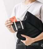 Mini Pouch | Tote Bag - A person holding a black mini tote pouch with a credit card inside, clipped to a larger black bag.