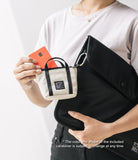 Mini Pouch | Tote Bag - A person holding a small beige canvas tote pouch with a credit card, attached to a large black bag by a carabiner.