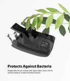 Mini Pouch | 2-Way Bag Miniature - Black textured mini pouch with a branded label, positioned under a green leaf on a white surface.