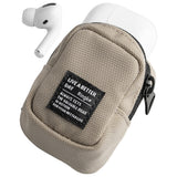 Mini Pouch | Block - Beige textured fabric pouch holding white wireless earbuds with a black branded label on the front.