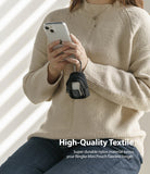 Mini Pouch | Block - Person in beige sweater holding a phone with a black nylon mini pouch clipped to their hand.