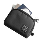Mini Pouch | Half-Pocket - Black textured mini pouch with a zipper and a branded label, holding three credit cards inside.