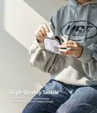 Mini Pouch | Half-Pocket - Person in a grey hoodie placing white wireless earbuds into a small, light purple nylon pouch.