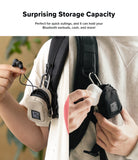 Mini Pouch | Block - Two views of a small pouch clipped to a backpack, holding earbuds and a charging case.