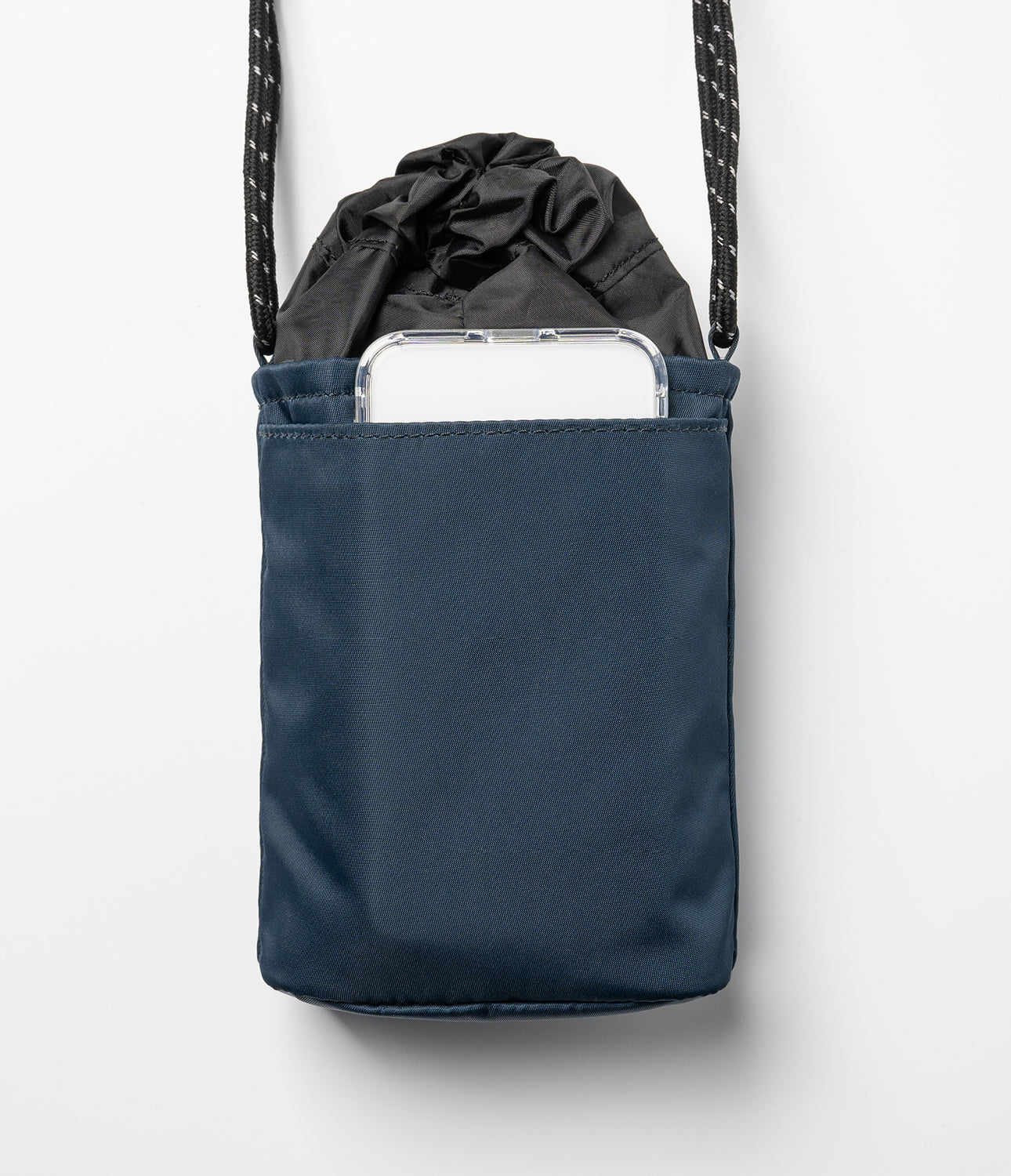 Mini Cross Bag | Bucket Bag - Navy blue bucket bag with a drawstring top and an exterior pocket holding a smartphone.