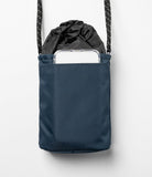 Mini Cross Bag | Bucket Bag - Navy blue bucket bag with a drawstring top and an exterior pocket holding a smartphone.