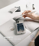 Card Holder | Magnetic Slot - A clear phone case with a magnetic card holder attached, resting on an open notebook with a pen.