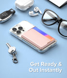 Card Holder | Magnetic Side Slot - Pink magnetic card holder attached to a clear phone case on a blue surface with accessories.