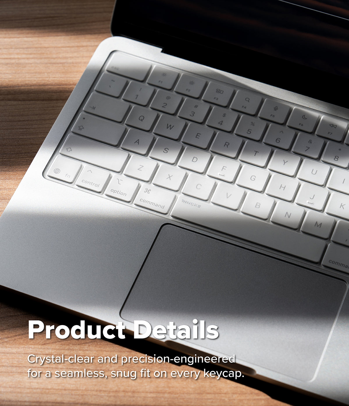MacBook Neo Case + Protector - Close-up of a silver laptop keyboard with a translucent clear keycap cover, resting on a wooden surface with soft sunlight and shadow. White text at the bottom reads 'Product Details' with descriptive copy about crystal-clear and precision-engineered keycaps.