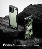 OnePlus 15R Case | Fusion-X - Two OnePlus 15R phones in black Fusion-X cases, one clear and one camo, resting on dark rocks.
