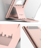 Outstanding | Tablet Stand - A rose gold foldable tablet stand with adjustable angle settings and a spring-loaded hinge mechanism.