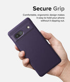 Google Pixel 7a Case | Onyx - A hand holding a textured dark purple phone case with a camera cutout against a white background.