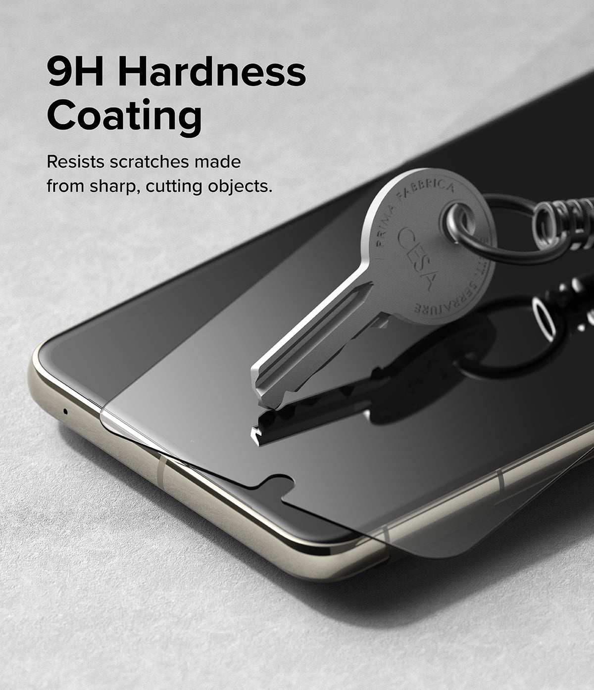 Google Pixel 8 Pro Screen Protector | Glass - A metal key resting on a screen protector, demonstrating 9H scratch resistance.