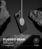 Google Pixel 9a Case | Rugged Gear Magnetic - A rugged black phone case suspended by a magnetic charger between rocks.