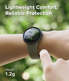 Pixel Watch 5 / 4 41mm | Slim (2P) - A smartwatch with a dark gray round case and a light gray strap is worn on a person's wrist, with a finger touching the strap. The background is a blurred green outdoor setting.