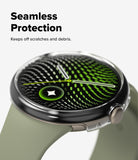 Pixel Watch 5 / 4 41mm | Slim (2P) - A smartwatch with a round silver-toned case and a light olive green strap, shown on a clean white background with promotional text reading 'Seamless Protection' and 'Keeps off scratches and debris.' The watch face displays a green and black patterned screen design.
