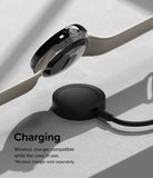 Google Pixel Watch 41mm | Premium Bezel Styling - A black smartwatch with a beige band hovering above a wireless charging puck.