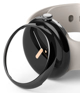 Google Pixel Watch 41mm | Bezel Styling - A glossy black protective bezel cover hovering over a black Pixel Watch.