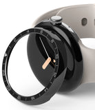 Google Pixel Watch 41mm | Premium Bezel Styling - A black numbered watch bezel hovering over a Pixel Watch with a beige band.