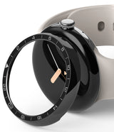 Google Pixel Watch 41mm | Premium Bezel Styling - A black numbered watch bezel hovering over a Pixel Watch with a beige band.