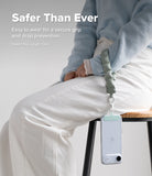 Holder Link Puffer | Hand - A person wearing a sage green quilted puffer wrist strap attached to a clear phone case.