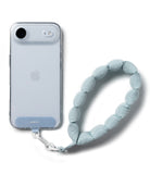 Holder Link Puffer | Hand - Clear phone case with a light blue fabric hand strap attached by a white clip.