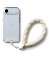 Holder Link Puffer | Hand - A clear phone case attached to a cream-colored, pillowy, bead-style wrist strap.