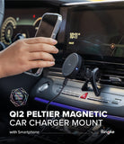Qi2 Peltier Magnetic Car Charger Mount - Hand holding a smartphone near a magnetic car vent mount with a cooling fan.