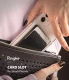 Card Holder | Slot [3 Cards] - A hand placing a smartphone with a black adhesive card holder into a textured black clutch.