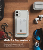 Card Holder | Slot [3 Cards] - Clear phone case with a card holder attachment holding three cards on a wooden desk with accessories.