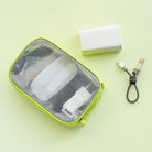Travel Organizer Pouch - Lime green mesh pouch containing tech accessories next to a power bank and a USB charging cable.