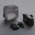 Travel Organizer Pouch - Grey mesh pouch with camera, USB cable, and memory card reader on a dark grey background.